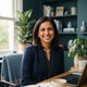 A smiling South Asian woman in a modern home office setting, representing a satisfied parent.