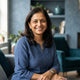 A friendly South Asian mother smiling, representing a satisfied customer for an educational product.